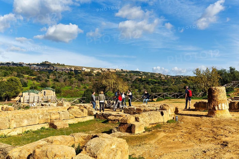 Tourist group, archaeological site in the Valley of the Temples, breathtaking landscape with ruins and olive trees, Cumulus, Agrigento, Sicily, Italy