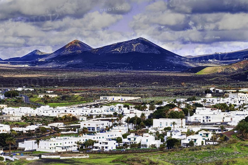 The municipality of Yaiza with white houses in a volcanic mountain landscape and cloudy sky, Yaiza Lanzarote