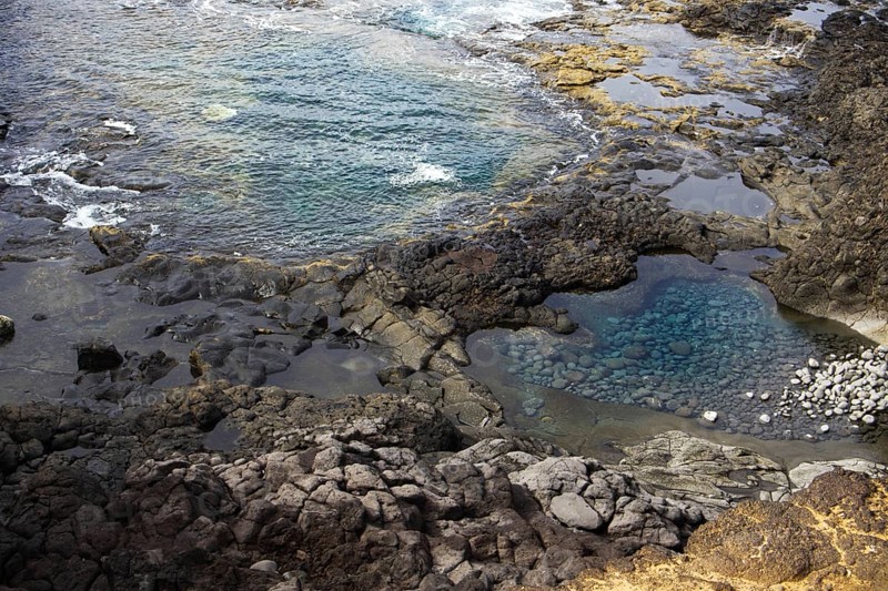 Rocky landscape with cliffs and natural pools with clear water on a rough, wave-driven coast, Yaiza Lanzarote