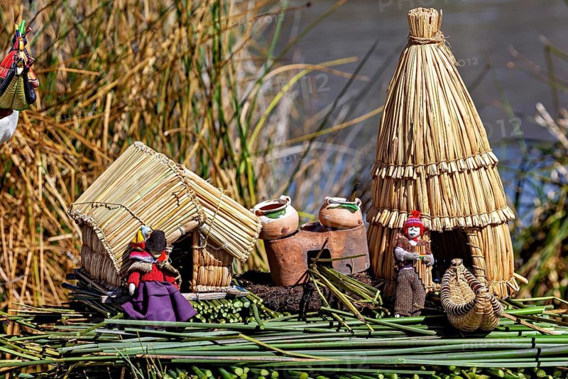 Miniature huts and figures made of straw and clay on a natural support, The floating reed islands of the Uros in Lake Titicaca in Peru