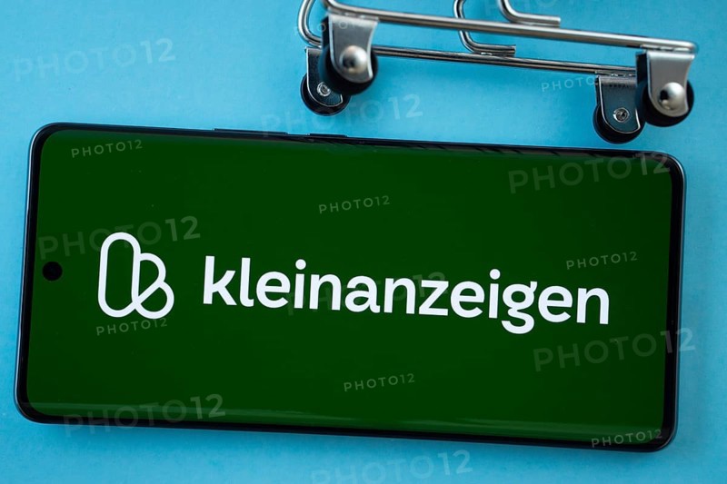 Dhaka, Bangladesh- 03 July 2025: Smartphone screen showing the Kleinanzeigen logo with shopping cart wheels on a blue background