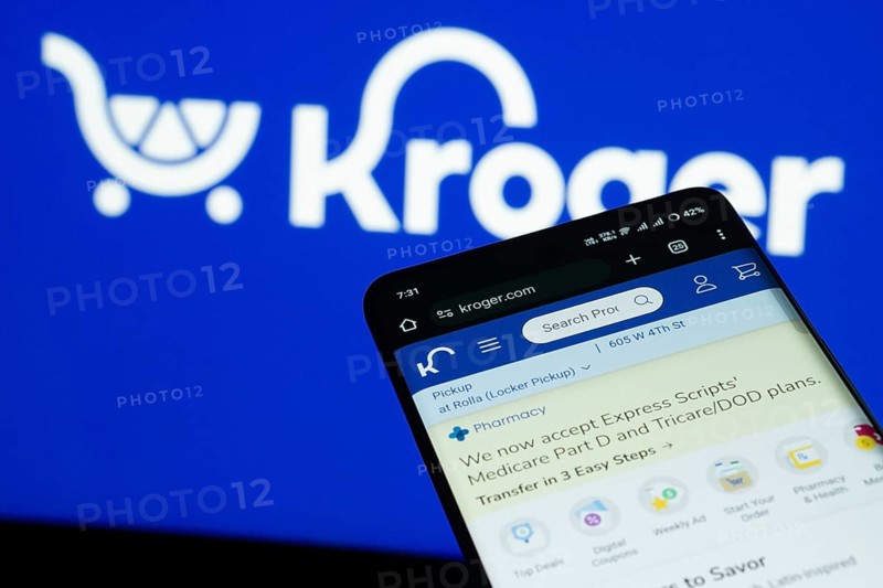 Dhaka, Bangladesh- 03 July 2025: Smartphone displaying Kroger web interface against Kroger logo background