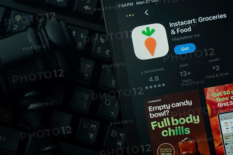 Dhaka, Bangladesh- 28 Oct 2025: An iPad displaying the Instacart app against a judge's gavel and dark keyboard background