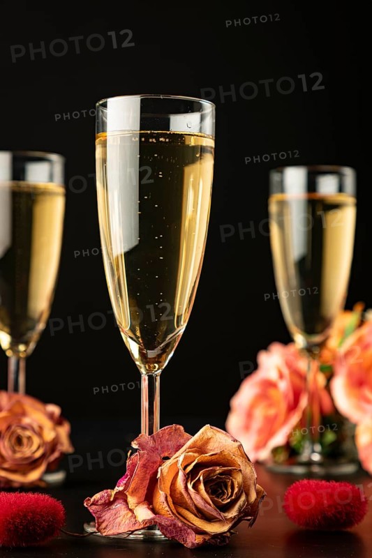 Three glasses with roses and hearts, dark background