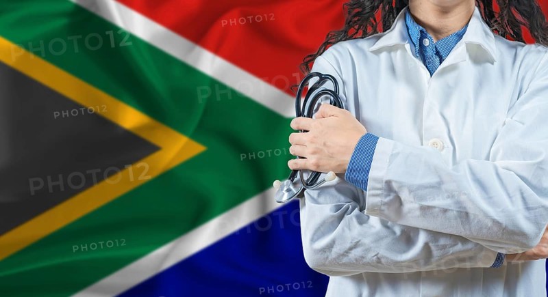 Healthcare professional with South Africa flag background. Professional doctor holding stethoscope on South Africa flag background