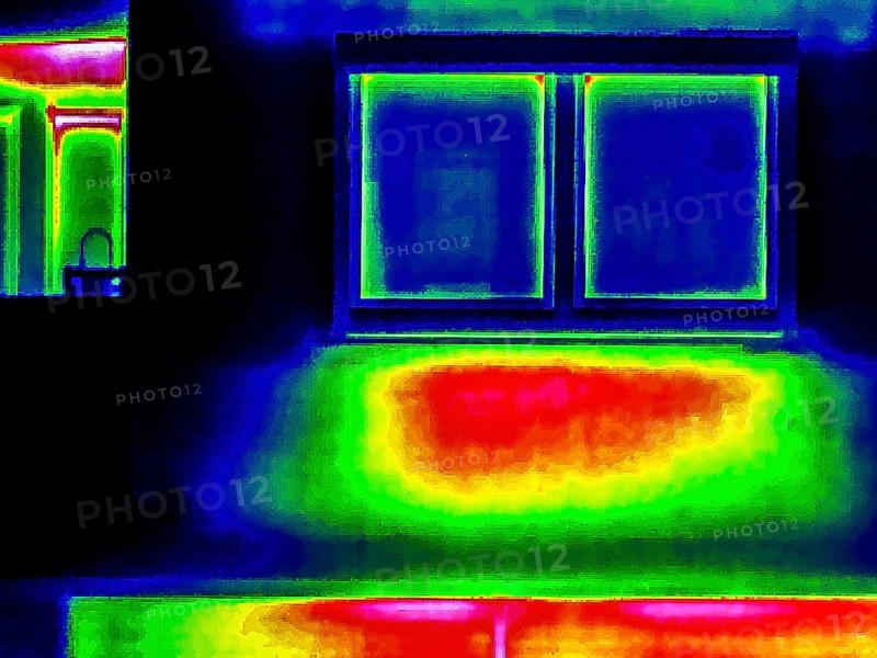 Thermal image or thermography, symbolic photo, interpolated. The photo shows areas of heat loss in a building. The red area below this window shows the placement of the radiator. Stuttgart, Baden-Württemberg, Germany