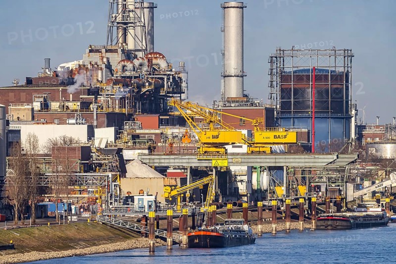 BASF factory site with chemical plants and chimneys. Baden aniline and soda factories. chemical plant. Port cranes unloading a cargo ship. Ludwigshafen am Rhein, Rhineland-Palatinate, Germany