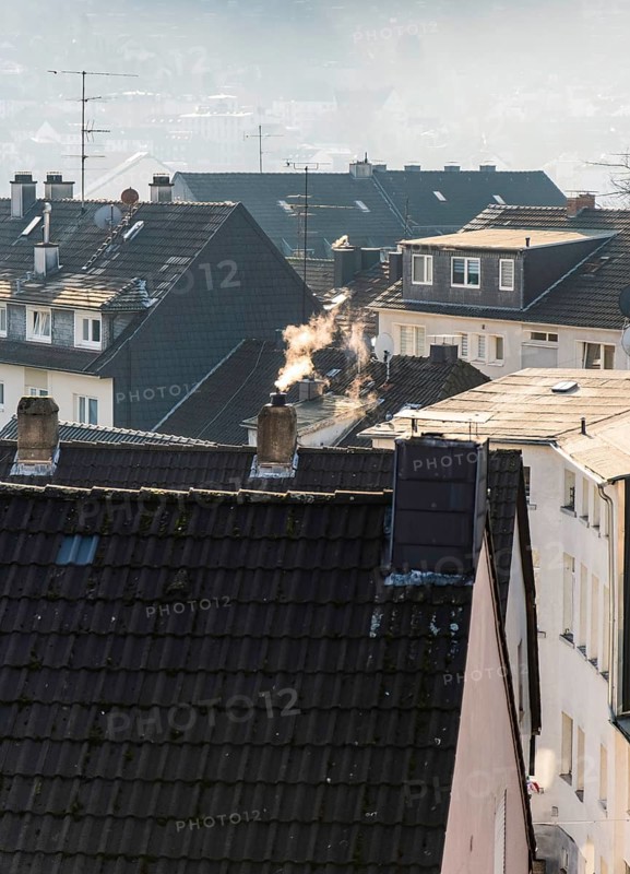 Smoke plume from a chimney over densely built residential area in the evening light, wintry city scene, Wuppertal, Germany