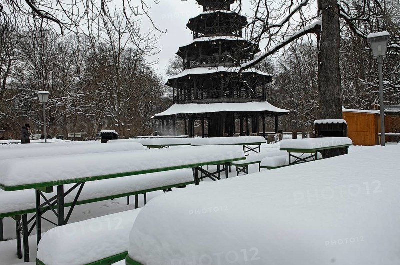Winter in the English Garden, snow-covered beer garden tables and benches, Chinese Tower, Munich, Bavaria, Germany