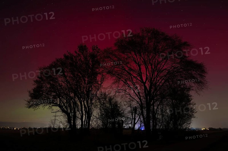Northern lights (aurora borealis) glow red and green in the evening sky over Germany, Frankfurt am Main, Hesse, Germany