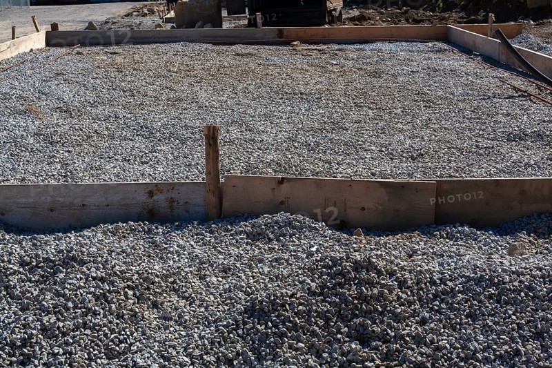 Wooden concrete pouring forms and bed of crushed and compacted stone aggregate to rest concrete slab floor of a building on at construction site, Quebec, Canada