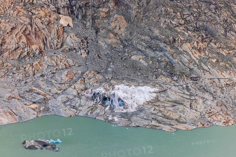 Remains of the Rhone Glacier ice cave covered with protective white geotextile sheets, highlighting climate change and global warming, Oberwald, Goms, Valais Canton, Switzerland