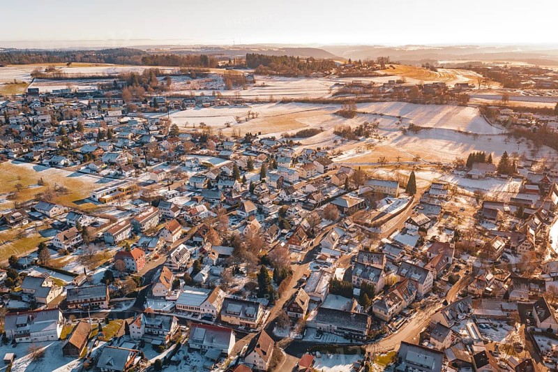 Aerial view of a snowy village with adjacent fields in the soft light of a winter sunset, Hallwangen, Freudenstadt district, Germany