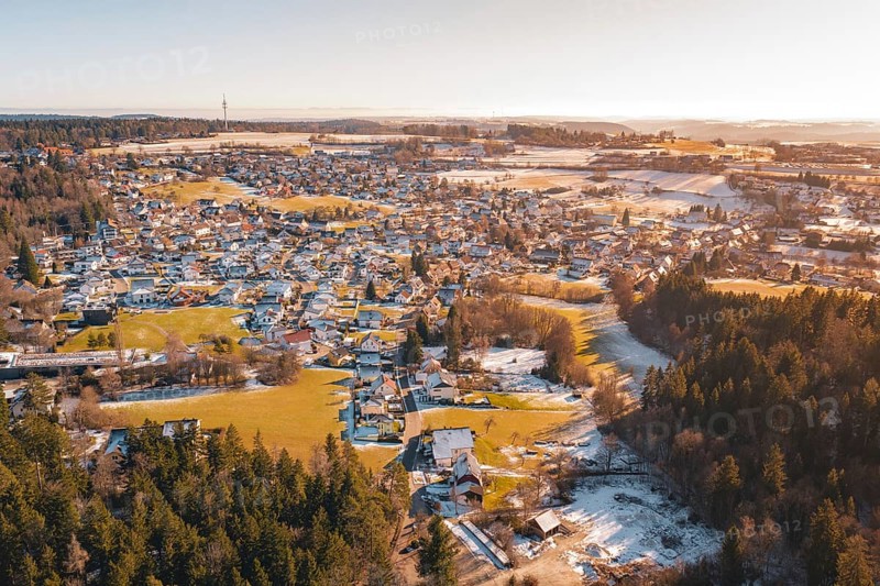 A village surrounded by forest and hills, with snow-covered areas and a river in winter, Hallwangen, Freudenstadt district, Germany