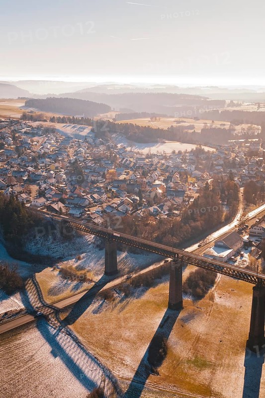 Aerial view of a snowy village and bridge with a wide view over the countryside, Aach, Dornstetten, Freudenstadt district, Germany
