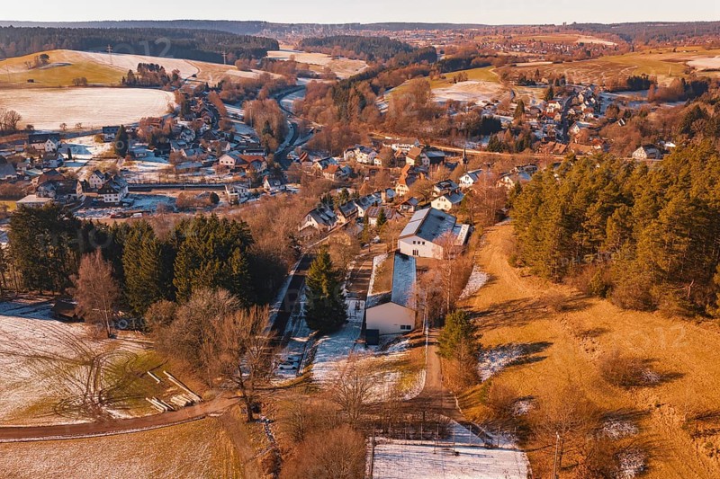 Snowy village nestled in a hilly landscape with forest and fields, Aach, Dornstetten, Freudenstadt district, Germany