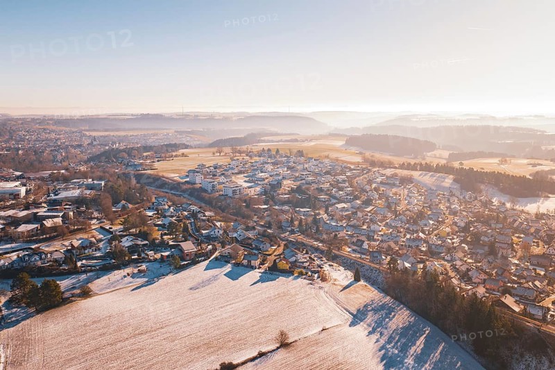 Aerial view of a snowy village in hilly landscape under bright sky, Aach, Dornstetten, Freudenstadt district, Germany