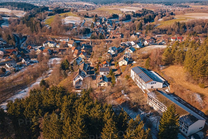 Panoramic view of a village with snow-covered roofs surrounded by forest and hills, Aach, Dornstetten, Freudenstadt district, Germany