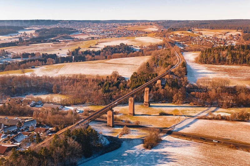 Winter landscape with a railroad bridge across fields and snow-covered hills, Dornstetten, Freudenstadt district, Germany