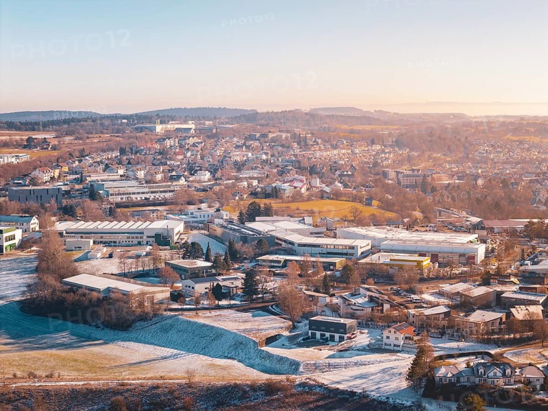 City view in winter with snow-covered fields and buildings under a foggy sky, Dornstetten, Freudenstadt district, Germany