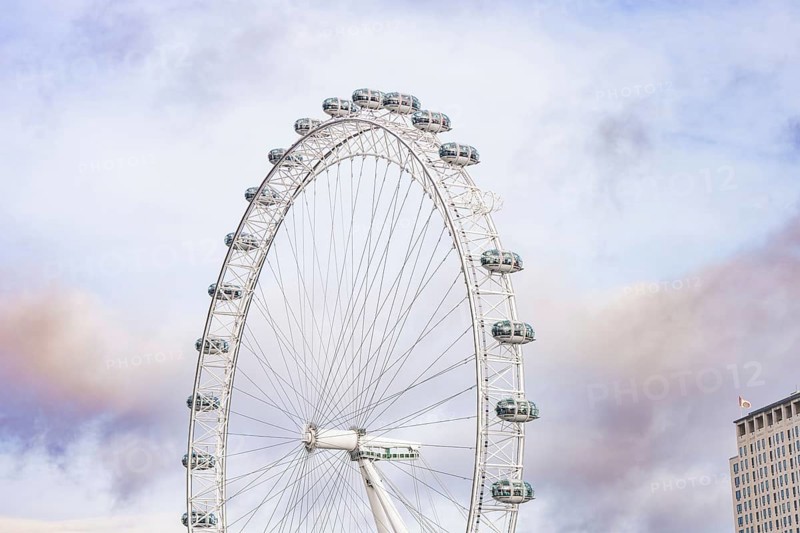 A large Ferris wheel stretches high over an urban backdrop, London Eye, London, United Kingdom