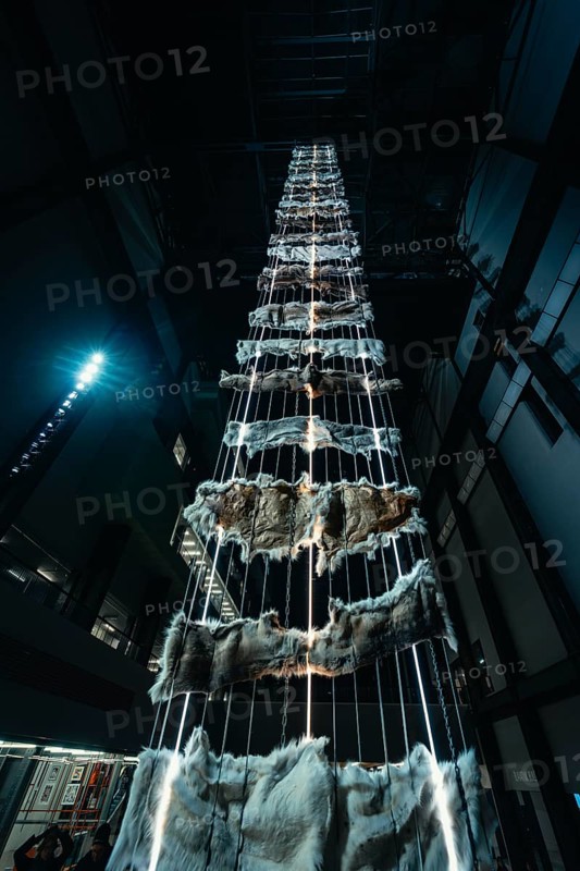 Tall vertical installation with metal and fur elements in a dark room, Tate Modern of Art, Lodon, United Kingdom