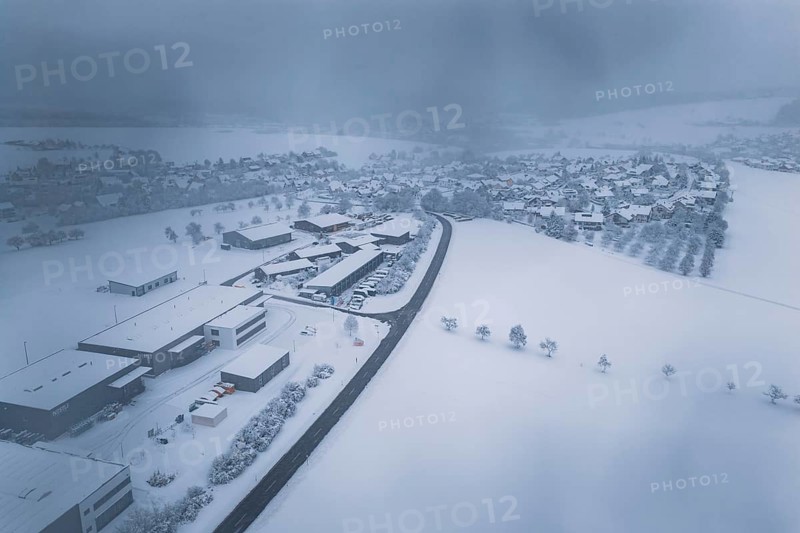 Wintery snowy village with buildings and roads under a thick blanket of fog, Hörschweiler, Freudenstadt district, Germany