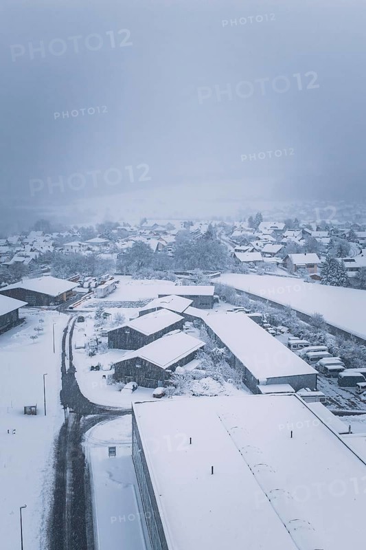 Snowy village landscape with buildings under a cloudy sky, Hörschweiler, Freudenstadt district, Germany