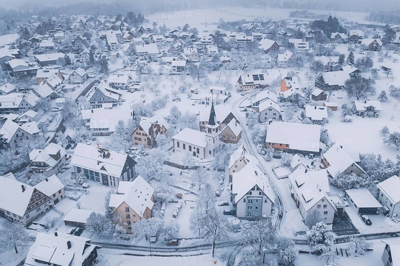 Snowy village with a church wrapped in a cold, peaceful atmosphere, Schopfloch, Freudenstadt district, Germany
