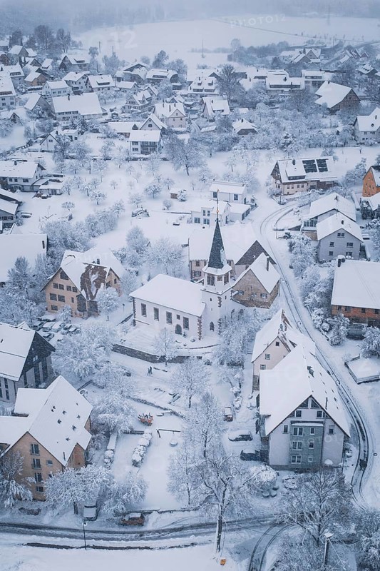 Winter landscape of a village with church and snowy roads, Schopfloch, Freudenstadt district, Germany