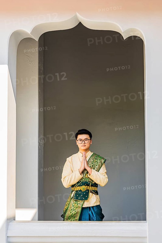 Young man in traditional clothing presenting himself to photographers, Wat Arun Buddhist temple, Bangkok, Thailand's metropolis, Thailand