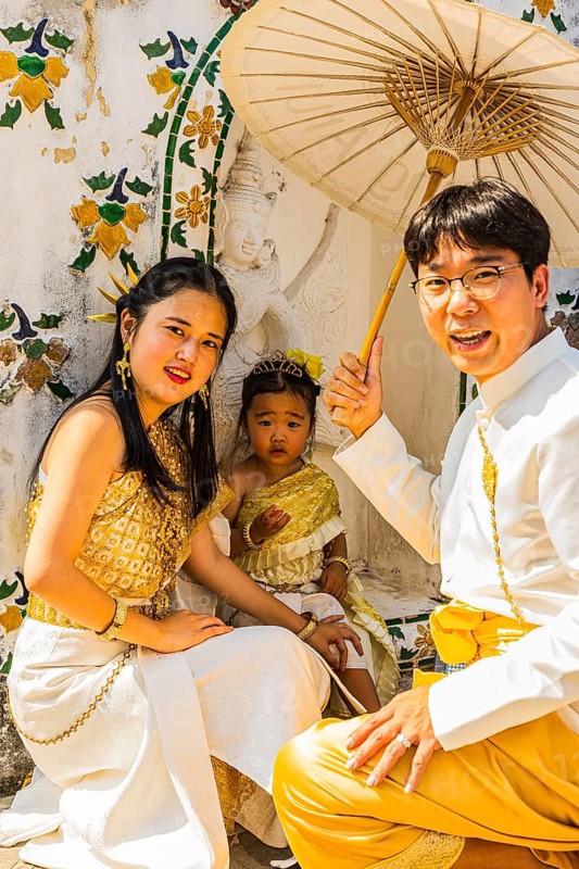 Young family with toddler and parasol in traditional clothing present themselves for the photographers, Buddhist temple Wat Arun, Bangkok, Thailand's metropolis, Thailand