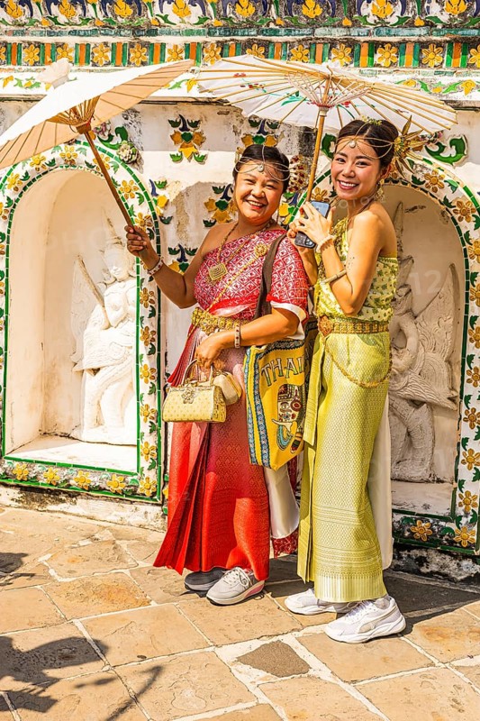 Young woman with umbrellas in traditional clothing present themselves for the photographers, Wat Arun Buddhist temple, Bangkok, Thailand's metropolis, Thailand