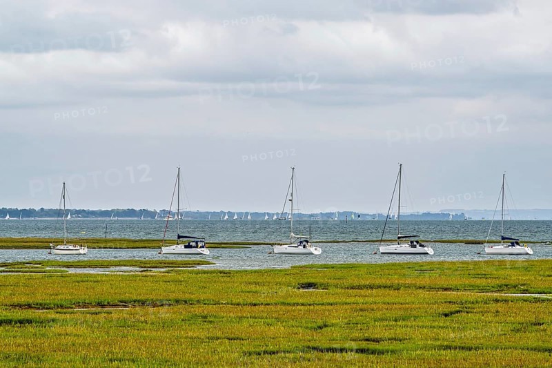 Boats over Hurst Point Lighthouse and Hurst Castle, Hurst Spit, Milford on Sea, Lymington, Hampshire, UK