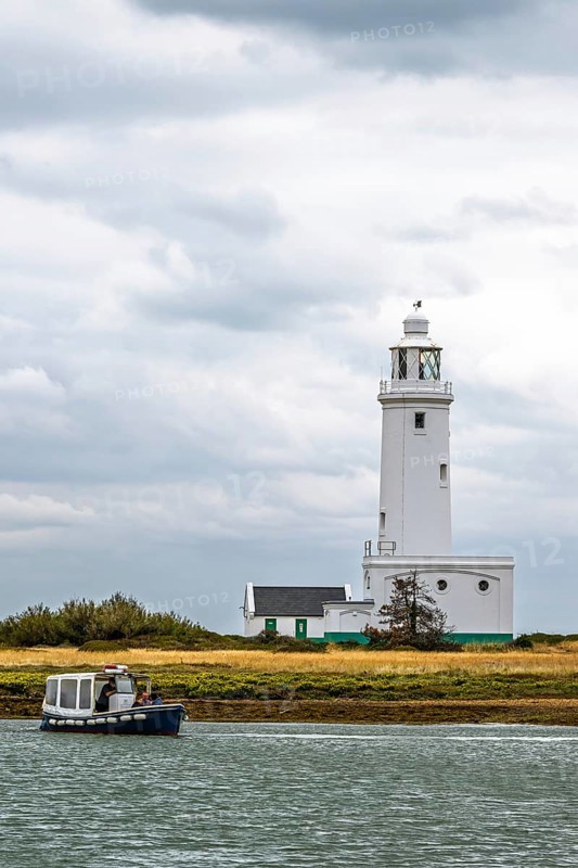 Boats over Hurst Point Lighthouse and Hurst Castle, Hurst Spit, Milford on Sea, Lymington, Hampshire, UK