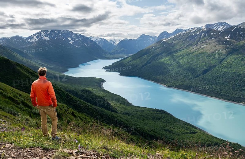 Mountaineer enjoys views of blue lake and mountains on Twin Peaks Trail, Eklutna Lake, Chugach Mountains, Chugach State Park, Alaska, USA