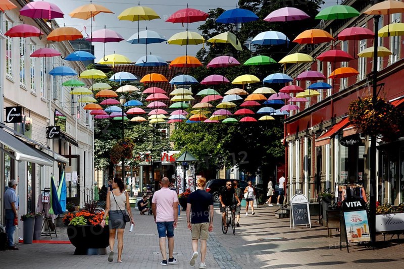 Colourful umbrellas decorate Dronningens gate, lively with passers-by, Trondheim, Norway