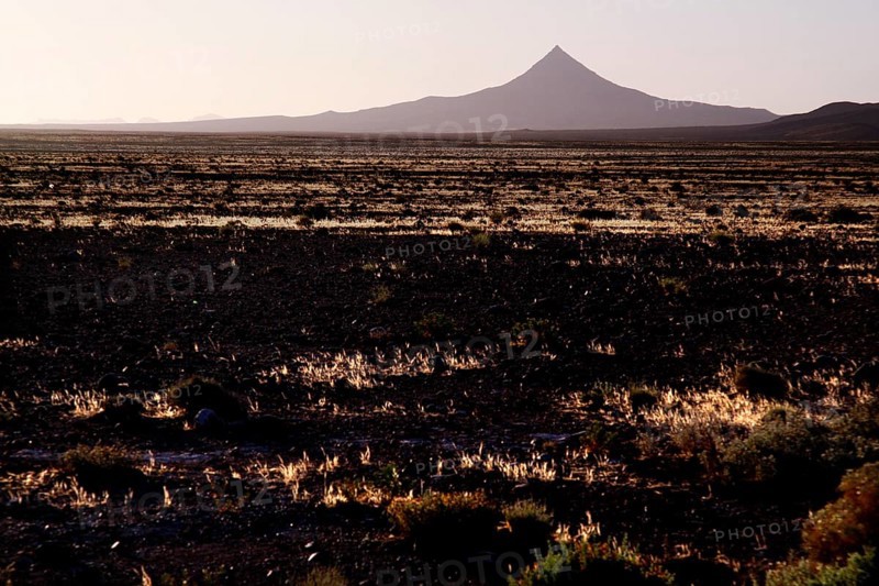 Volcano-like mountain rises from pristine desert landscape, Gourrama, Morocco