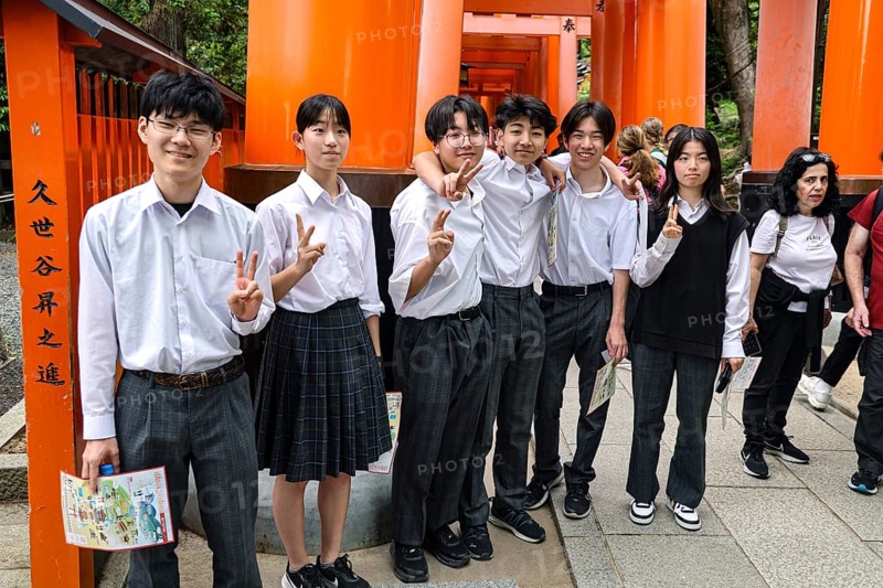 Students pose in front of torii at Fushimi Inari Shrine in Kyoto, Fushimi, Kyoto, Japan