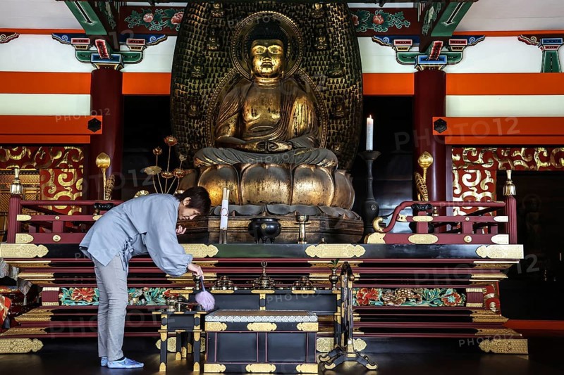 Woman cleaning a magnificent Buddha temple altar, Kyoto, Higashiyama, Japan