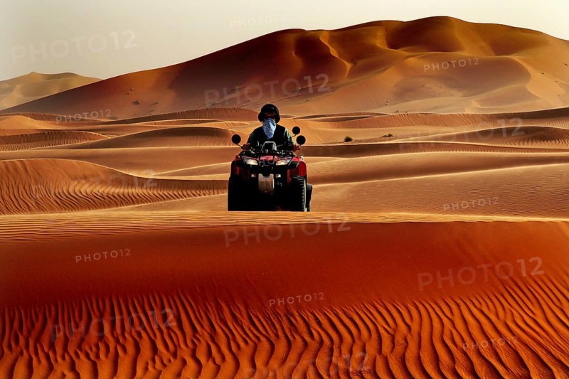 Person riding a quad bike through the vast sand dune landscape of Erg Chebbi, Erg Chebbi, Morocco