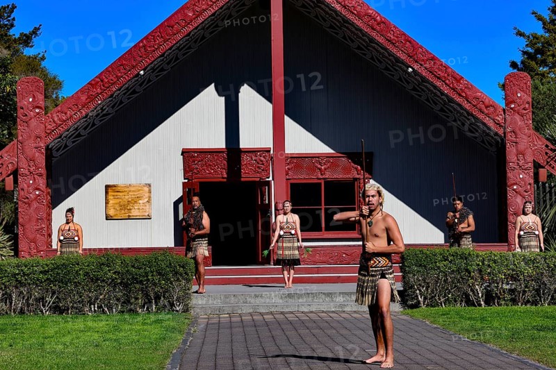 Maori group performs a welcoming ceremony in front of a traditional marae in Rotorua, Rotorua, Bay of Plenty, New Zealand