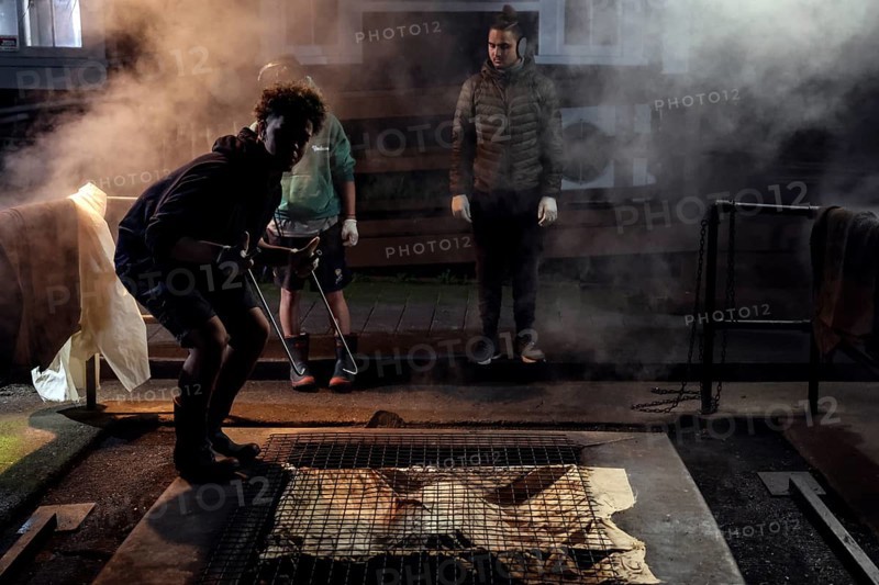 People prepare a traditional hangi in a steaming earth pit in Rotorua, Rotorua, Bay of Plenty, New Zealand