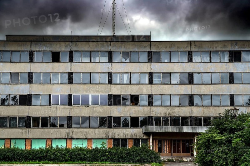 Dilapidated prefabricated building with empty windows under dramatic sky, Liepaja, Karosta, Latvia