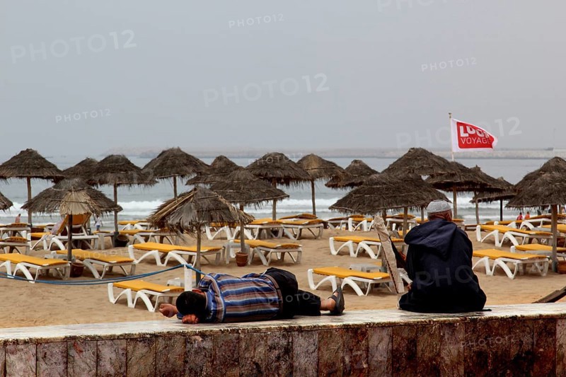 Umbrellas and sun loungers line Agadir beach, where gentle waves break, Agadir, Morocco