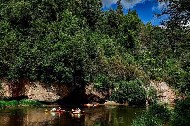 Lined river in Gauja National Park with canoe and steep rocks in the background, Gauja National Park, Latvia