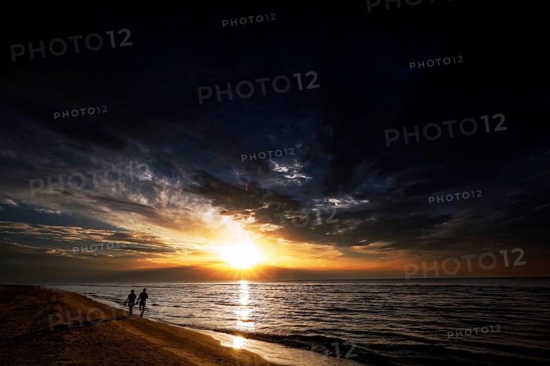 Sunset on Kolka beach with walkers on the shore, Kolka, Latvia