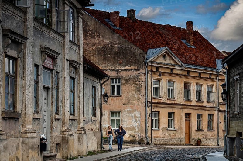 People walk through old town streets with old buildings in Kuldiga, Kuldiga, Latvia