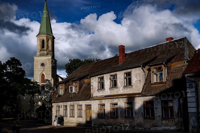 St. Catherine's Church and old houses under dramatic skies in the old town, Kuldiga, Latvia