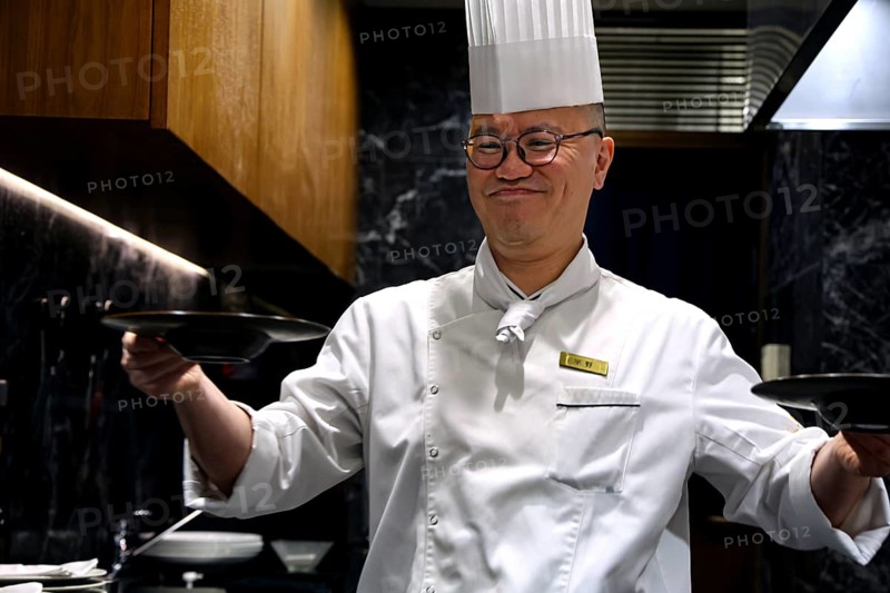 Chef with cap serves soup smiling at Kobe Plaisir restaurant, Kobe, Hyogo, Japan
